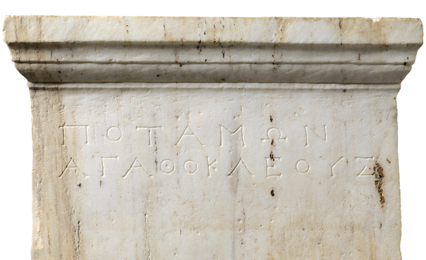 Το πάνω τμήμα μαρμάρινης επιτύμβιας στήλης με επιγραφή: μέσα 3ου αι. π.Χ., Αρχαιολογικό μουσείο Πέλλας